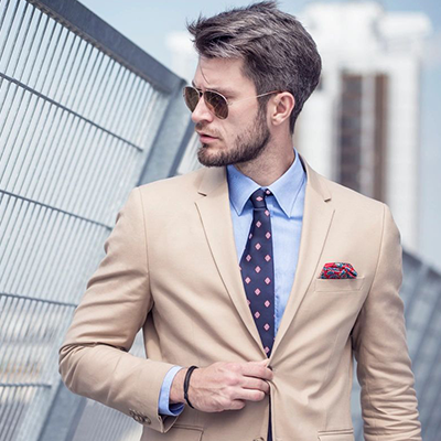 A man in a suit and tie standing outside.