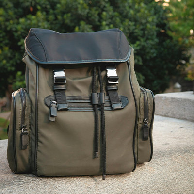 A backpack sitting on top of a cement block.