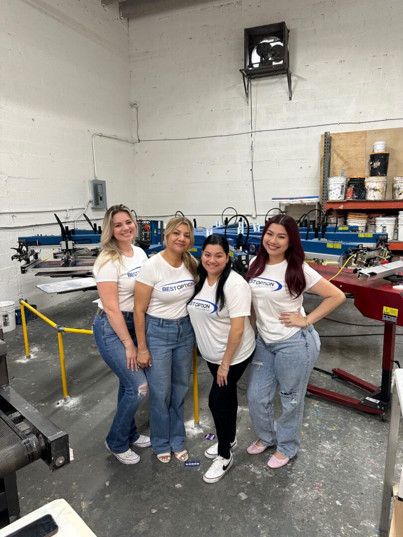 Four women standing in a room with some machines.