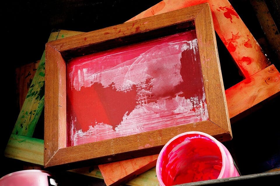 A red painting is sitting on some paper