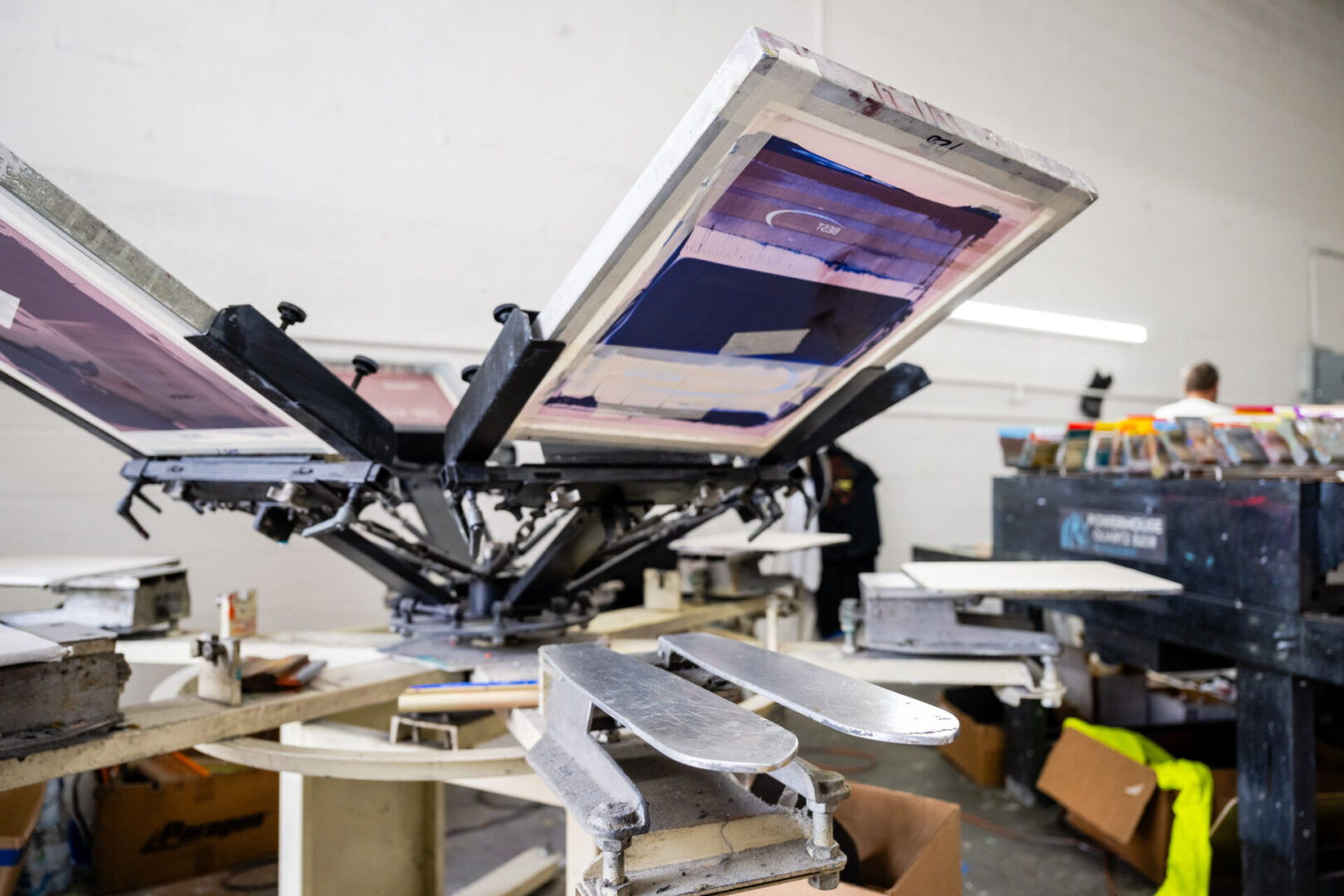 A person is working on an object in a printing press.